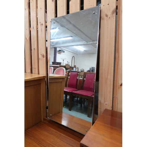 114 - A mid 20th century teak mirror backed dressing table with mirror offset from three pairs of graduati... 