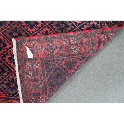 68 - A pink ground balouch rug with allover flower head pattern ground and geometric floral border, 179cm... 