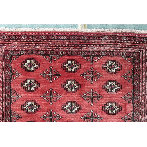 69 - A red ground bokhara rug with all over lozenge design and multiple borders, 105cm long x 83cm wide