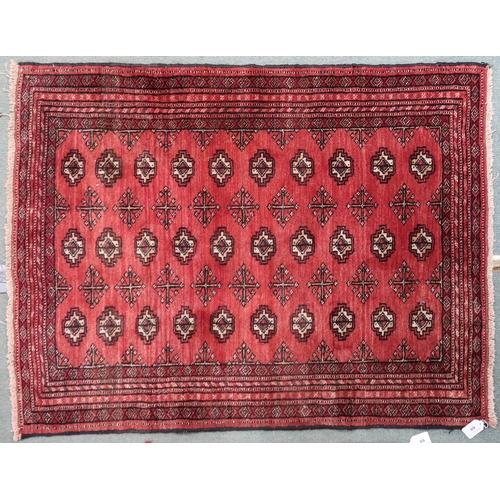 69 - A red ground bokhara rug with all over lozenge design and multiple borders, 105cm long x 83cm wide