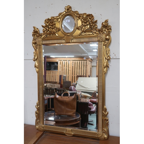 81 - A 20th century gilt framed rococo style wall mirror, 125cm high x 78cm wide 