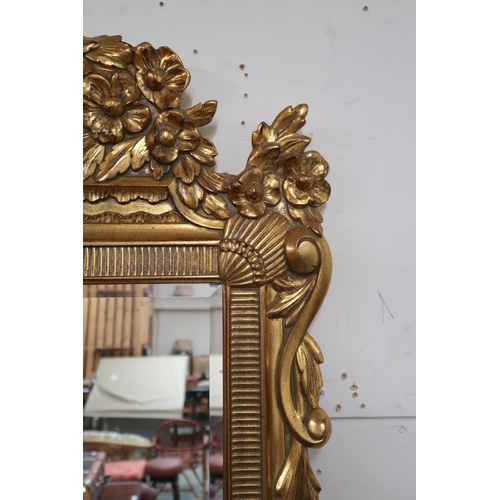 81 - A 20th century gilt framed rococo style wall mirror, 125cm high x 78cm wide 