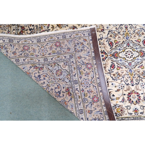 2139 - A CREAM GROUND KESHAN RUG with pale blue diamond shaped central medallion, matching spandrels on mul... 