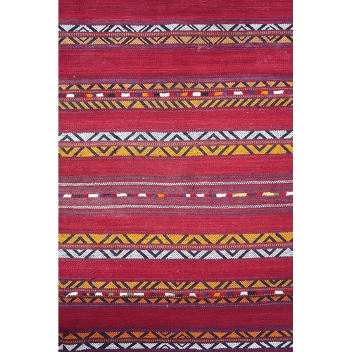 2142 - A RED GROUND MOROCCAN RUGwith multicoloured striped design, 298cm long x 196cm wide... 