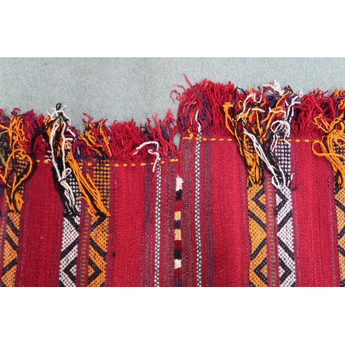 2142 - A RED GROUND MOROCCAN RUGwith multicoloured striped design, 298cm long x 196cm wide... 