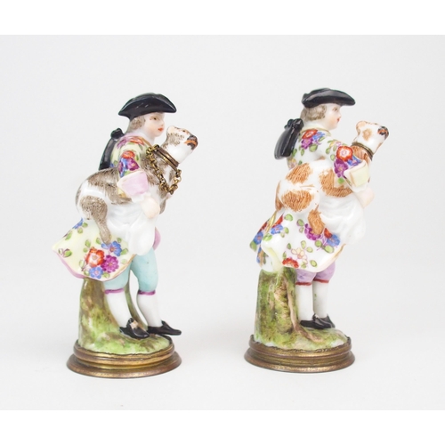 2166 - A PAIR OF CONTINENTAL, PROBABLY GERMAN PORCELAIN PERFUME BOTTLES each modelled as a man holding a do... 
