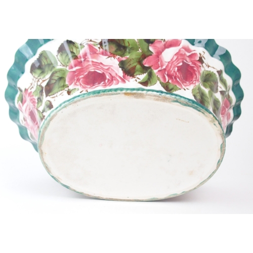 2176 - THREE WEMYSS GRADUATED BASKETS each of oval form and painted with cabbage roses, with green rope twi... 