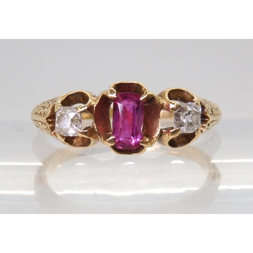 2705 - A VINTAGE THREE STONE RINGset with two old cut diamonds and a mixed cut ruby in a scroll engraved se... 