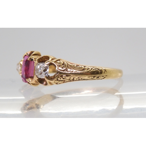 2705 - A VINTAGE THREE STONE RINGset with two old cut diamonds and a mixed cut ruby in a scroll engraved se... 