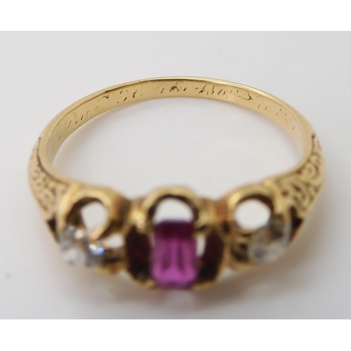 2705 - A VINTAGE THREE STONE RINGset with two old cut diamonds and a mixed cut ruby in a scroll engraved se... 