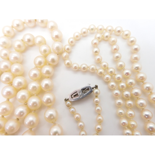 2716 - TWO STRINGS OF PEARLS WITH DECORATIVE CLASPSthe smaller strand, the pearls taper in size from 7mm to... 