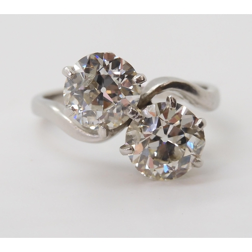 2720 - A SUBSTANTIAL TWIN STONE DIAMOND RINGset with two old cut diamonds with an estimated approx diamond ... 