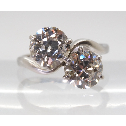 2720 - A SUBSTANTIAL TWIN STONE DIAMOND RINGset with two old cut diamonds with an estimated approx diamond ... 