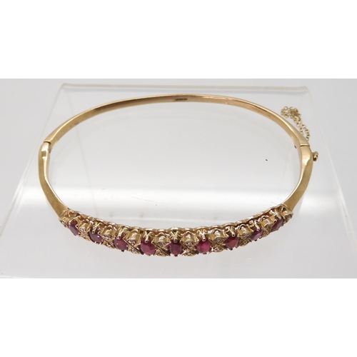 2728 - A 9CT RED GEM & DIAMOND BANGLEwith decorative galleried mount, inner diameter 6.2cm, weight 9.7g... 