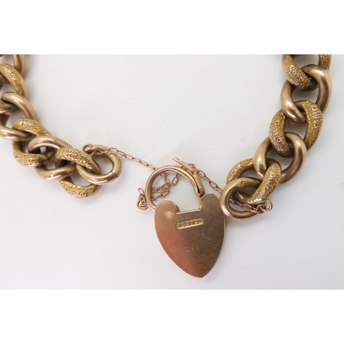 2742 - A 9CT GOLD CURB CHAIN BRACELETwith heart-shaped clasp, hollow construction with alternate links text... 