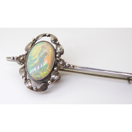 2745 - AN ARTS & CRAFTS OPAL BROOCHset with a 16mm x 11.5mm solid opal with exceptional orange, red, gr... 