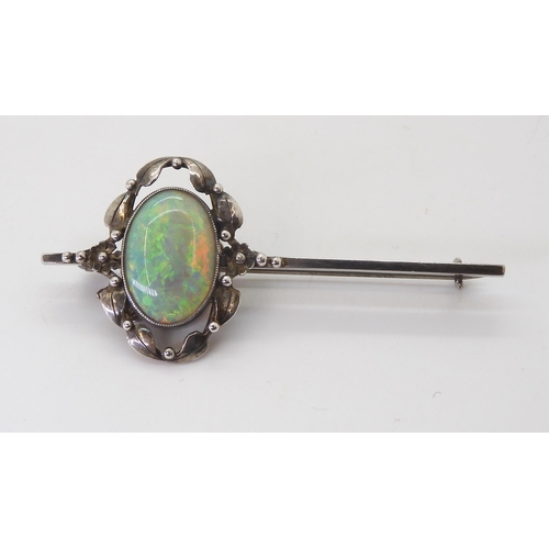 2745 - AN ARTS & CRAFTS OPAL BROOCHset with a 16mm x 11.5mm solid opal with exceptional orange, red, gr... 