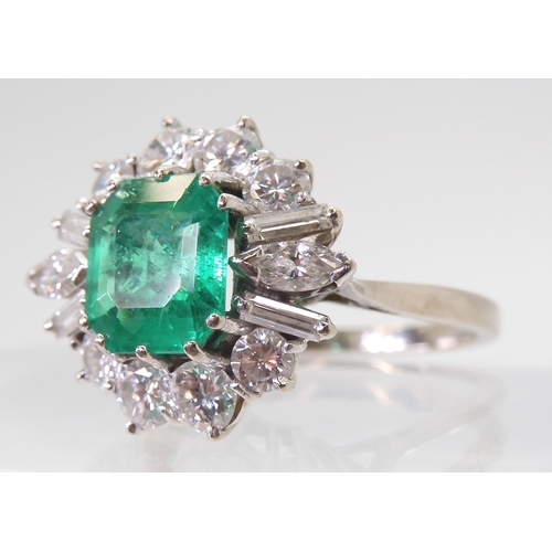 2747 - AN EMERALD & DIAMOND CLUSTER RINGset with a step cut emerald of approx 8.95mm x 8.33mm x 4.6mm i... 