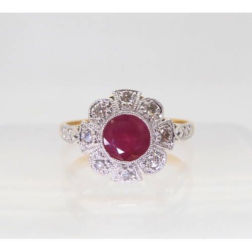 2825 - A VINTAGE RUBY AND DIAMOND RINGset with a central ruby surrounded with eight cut diamonds, to a flow... 