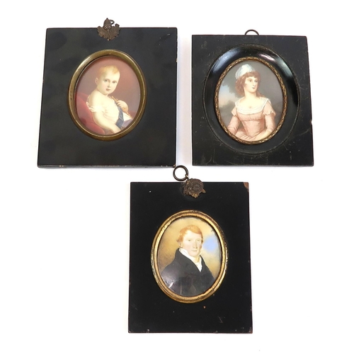 2569 - THREE EARLY-19th CENTURY PORTRAIT MINIATURESPainted on ivory, depicting respectively a red-haired ge... 