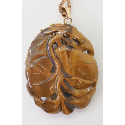 2790 - A CHINESE PENDANT CARVED WITH A RABBITcarved in tiger's eye the rabbit is depicted with pumpkins, mo... 