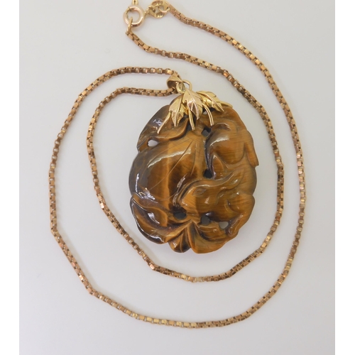 2790 - A CHINESE PENDANT CARVED WITH A RABBITcarved in tiger's eye the rabbit is depicted with pumpkins, mo... 