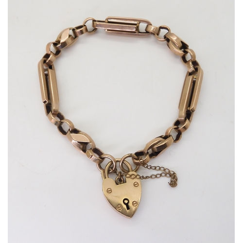 2763 - A 9CT FANCY LINK BRACELETwith heart shaped clasp and alternate twisted and baton links, with soldere... 