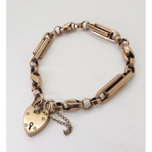 2763 - A 9CT FANCY LINK BRACELETwith heart shaped clasp and alternate twisted and baton links, with soldere... 