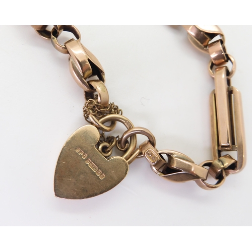 2763 - A 9CT FANCY LINK BRACELETwith heart shaped clasp and alternate twisted and baton links, with soldere... 