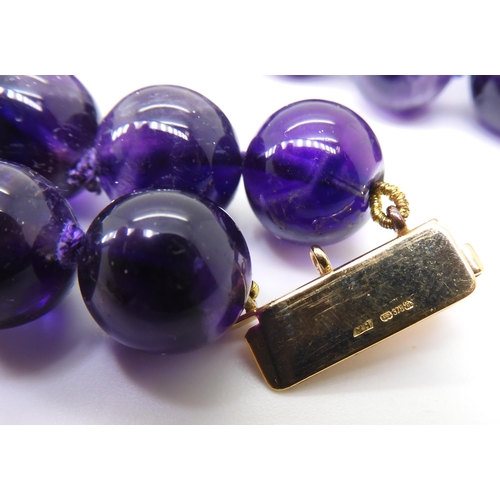 2764 - A STRING OF LARGE AMETHYST BEADSeach bead is approx 11mm, interspaced at intervals with 9ct barrel b... 