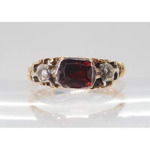 2766 - A GEORGIAN STYLE RINGmounted in yellow metal set with a red gem and rose cut diamonds, finger size a... 