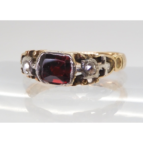 2766 - A GEORGIAN STYLE RINGmounted in yellow metal set with a red gem and rose cut diamonds, finger size a... 