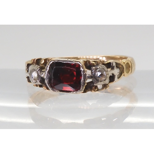 2766 - A GEORGIAN STYLE RINGmounted in yellow metal set with a red gem and rose cut diamonds, finger size a... 