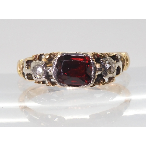 2766 - A GEORGIAN STYLE RINGmounted in yellow metal set with a red gem and rose cut diamonds, finger size a... 