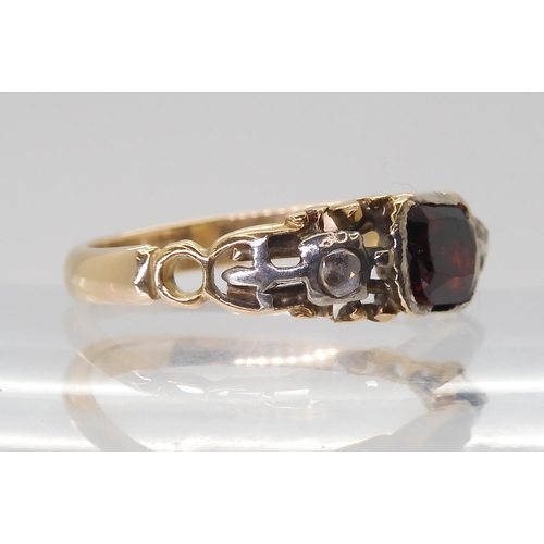 2766 - A GEORGIAN STYLE RINGmounted in yellow metal set with a red gem and rose cut diamonds, finger size a... 