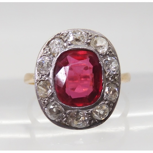 2769 - A VINTAGE RED GEM & DIAMOND RINGthe ring is mounted in yellow and white metal and set with a syn... 