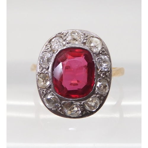 2769 - A VINTAGE RED GEM & DIAMOND RINGthe ring is mounted in yellow and white metal and set with a syn... 