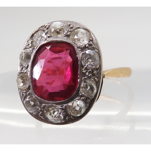 2769 - A VINTAGE RED GEM & DIAMOND RINGthe ring is mounted in yellow and white metal and set with a syn... 