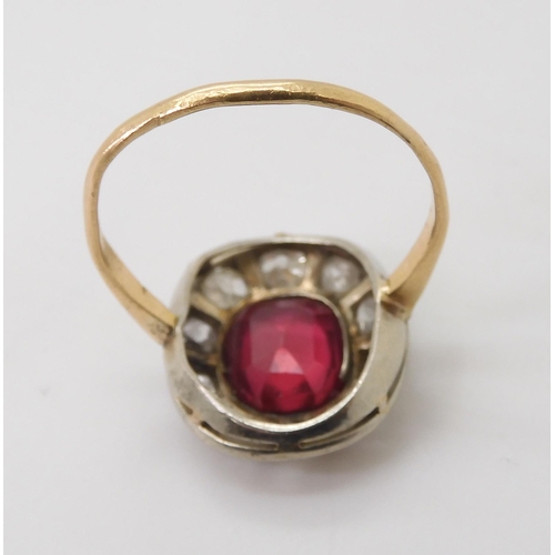 2769 - A VINTAGE RED GEM & DIAMOND RINGthe ring is mounted in yellow and white metal and set with a syn... 