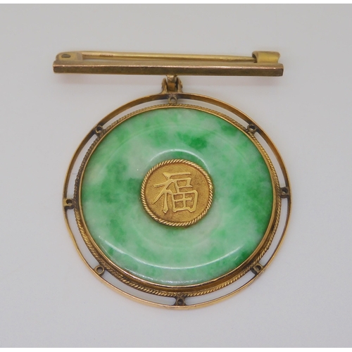 2815 - A CHINESE GREEN HARDSTONE RONDEL BROOCHthe centre with Chinese symbol, in a twisted wirework 9ct gol... 