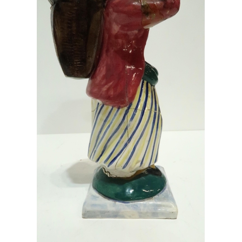 275 - A Scottish pottery figure modelled as a fisherwoman, carrying a creel on her back