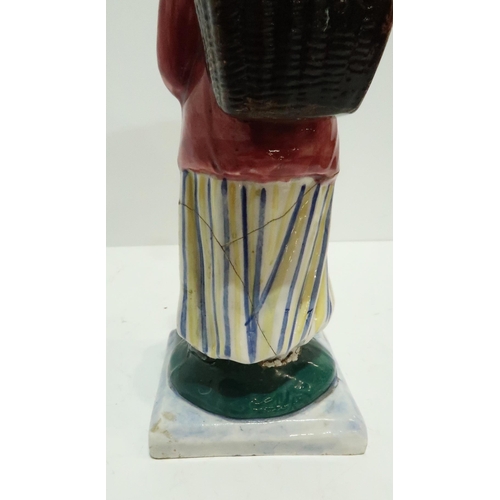 275 - A Scottish pottery figure modelled as a fisherwoman, carrying a creel on her back