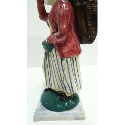 275 - A Scottish pottery figure modelled as a fisherwoman, carrying a creel on her back