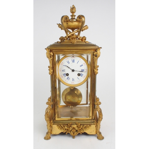 320 - A French gilded brass and glass timepiece, of tall rectangular form, the top with flaming urn and to... 