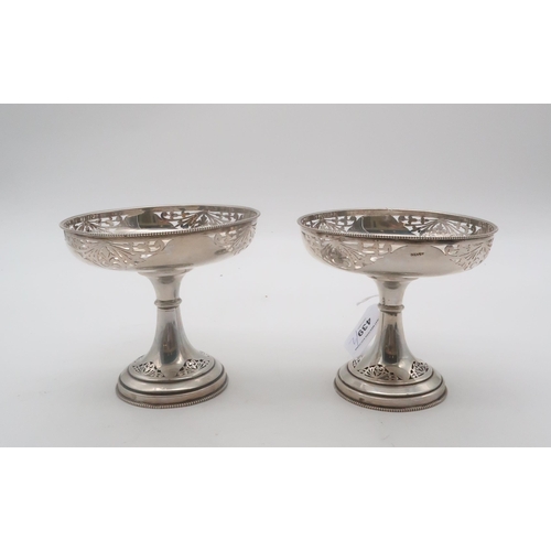 439 - A pair of stamped silver comports, the bowl and flaring stem with floral open work, 360gms