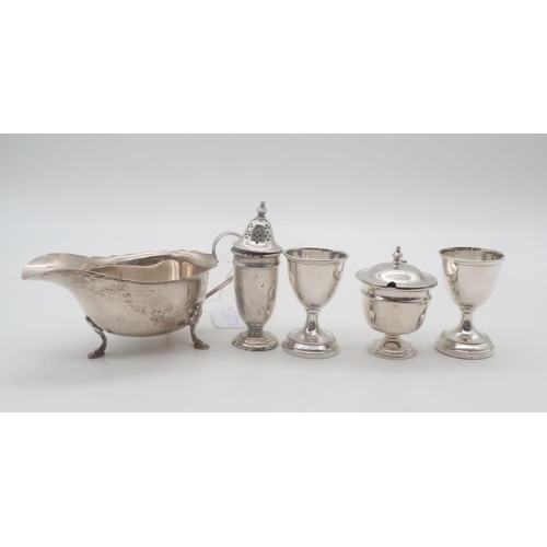 455 - A silver sauce boat, by Mappin & Webb, Sheffield, two white metal egg cups (bases weighted), par... 