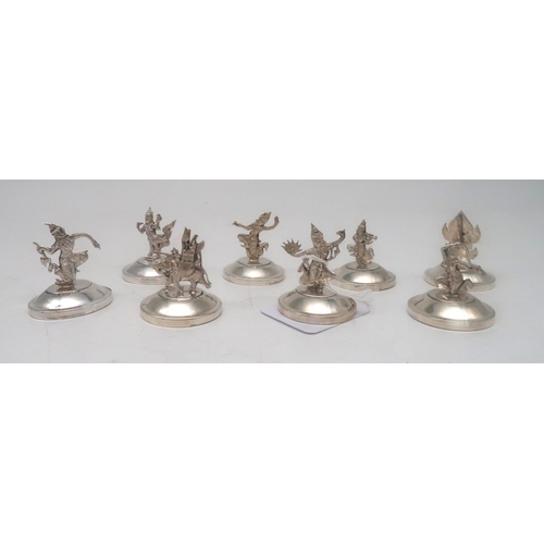 464 - A set of eight Siamese silver figural menu stands, modelled as various deities (loaded), stamped Sia... 