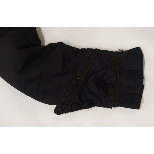 250 - A Victorian black satin skirt bustle, bodice and collar, the inside edges of the material printed wi... 