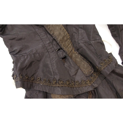 250 - A Victorian black satin skirt bustle, bodice and collar, the inside edges of the material printed wi... 