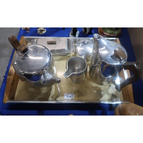 316 - A four piece Picquotware teaset on tray and a stainless steel butter dish